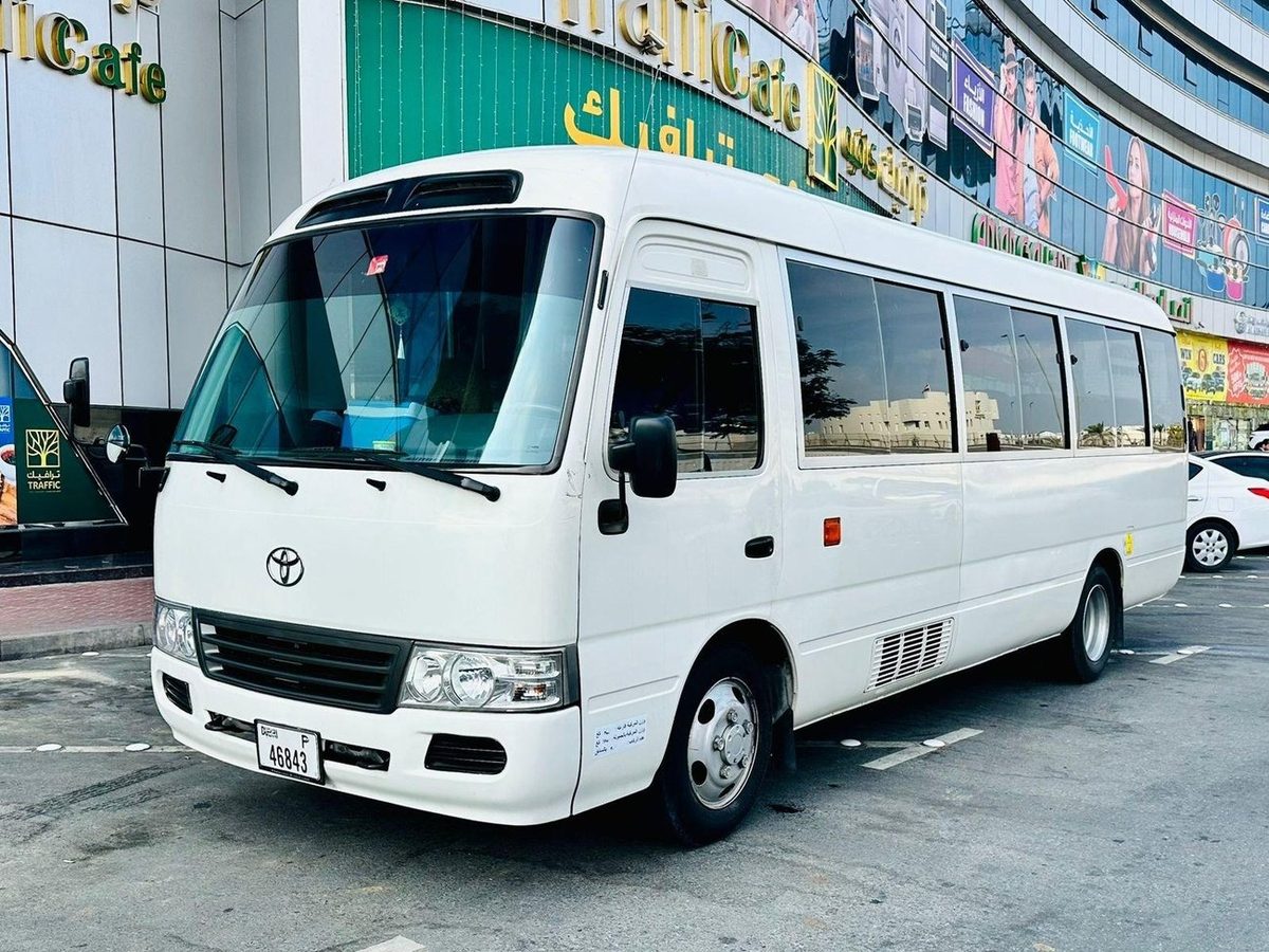 White Toyota Coaster bus parked in Dubai before the morning staff pick up